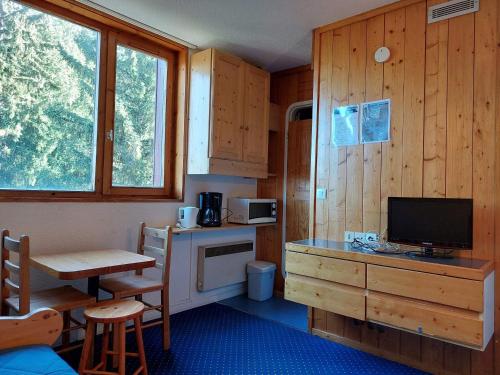 Cette chambre comprend une cuisine avec un bureau et une télévision. dans l'établissement Studio cosy pour 2 personnes, proche pistes et commodités, Arc 1800 - FR-1-411-293, à Arc 1800