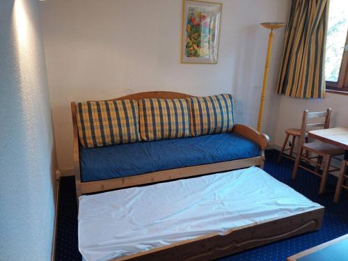 - un lit dans une chambre avec un canapé et une table dans l'établissement Studio cosy pour 2 personnes, proche pistes et commodités, Arc 1800 - FR-1-411-293, à Arc 1800