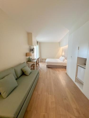 a living room with a couch and a bed at Hotel & Apartaments Thalassa Sport & Wellness in Roses