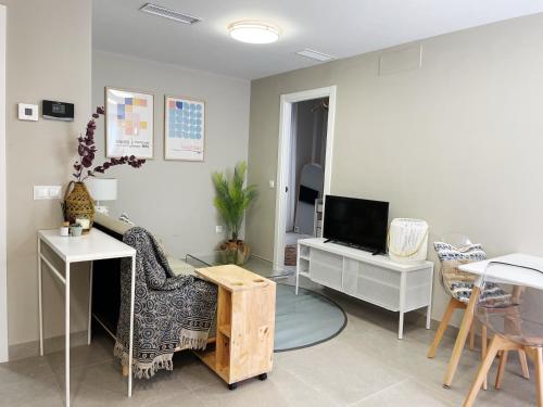 a living room with a tv and a chair and a table at Apartamentos Martalia Namar centro in Ronda