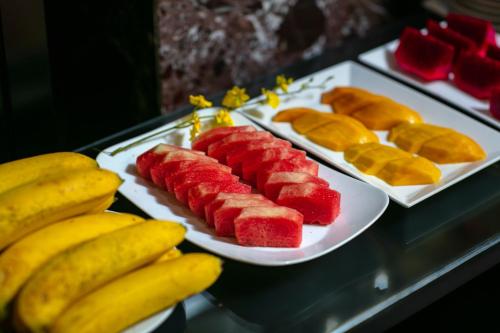 a table with two plates of fruit and bananas at Lavender Central Hotel & Spa Hanoi in Hanoi
