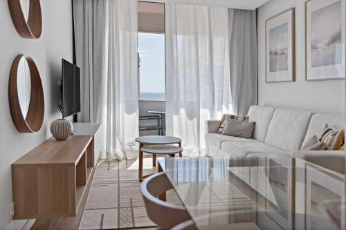 a living room with a couch and a glass table at Timeless Sea III Apartment in Armação de Pêra