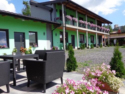 a patio with chairs and flowers in front of a building at Noclegi-SKAŁKA in Olsztyn