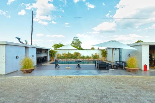a patio with umbrellas and tables and chairs at The Cubes in Lusaka