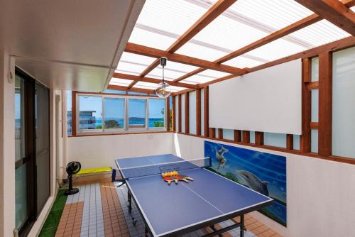a room with a ping pong table in it at BANKSHI-SA in Motobu