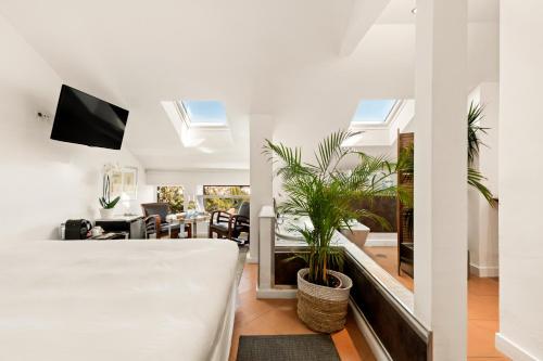 Molo Luxury Suites Puerto Banus في مربلة: غرفة نوم مع سرير وغرفة معيشة