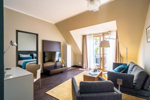 uma sala de estar com um sofá e uma cama em The Green Rostock Apartment Hotel em Rostock