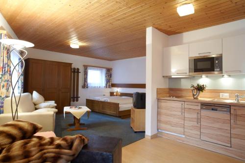 ein Wohnzimmer mit einem Sofa und einer Küche in der Unterkunft Appartements Hotel-Garni Dolce Vita in Samnaun