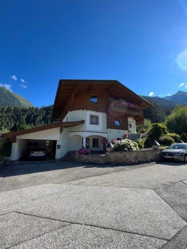 un gran edificio de madera con coches aparcados en un aparcamiento en Ferienwohnung Gertraud und Peter Geisler en Finkenberg