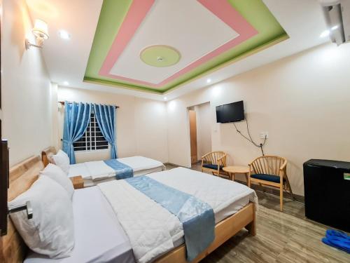 a hotel room with two beds and a tv at Hotel Nắng in Vung Tau