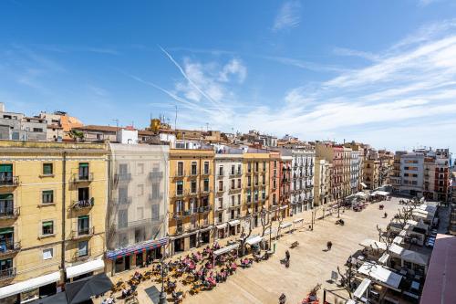 Apartamentos Centricos en Tarragona في تاراغونا: مجموعة من الناس يتجولون في مدينة بها مباني