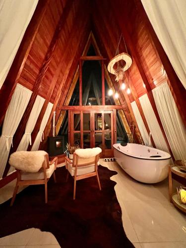 a bathroom with a tub and a table and chairs at Pousada Maçã Araucária in São Joaquim
