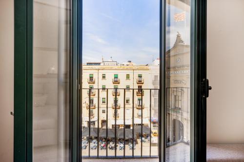een raam met uitzicht op een groot gebouw bij Apartamentos Centricos en Tarragona in Tarragona