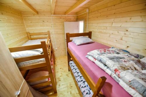 a bedroom with two beds in a wooden cabin at Sojenica Tamara in Ulcinj