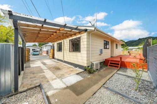 a small house with a red bench in front of it at Trentham Gem in Upper Hutt