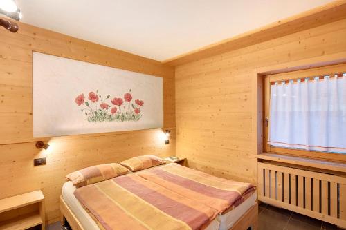 1 dormitorio con cama y ventana en Residence Attila Giardino, en Livigno