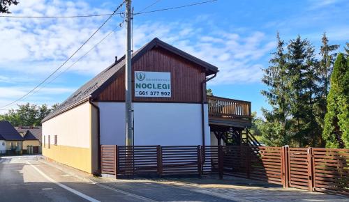 a building with a sign on the side of it at Noclegi Pod Modrzewiem in Powidz