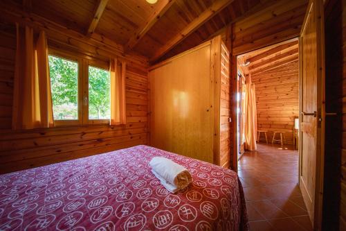 1 dormitorio con 1 cama en una cabaña de madera en Camping Els Ports en Arnes