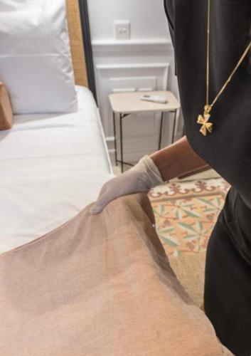 a person is making a bed in a room at Casa Maria Tereza in Cospicua