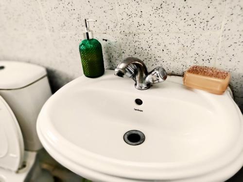 a bathroom sink with a soap bottle on it at Entire Studio Apt/Suite near Mall/Metro/ExpoMart in Noida