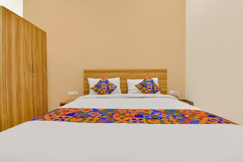 Un dormitorio con una cama grande con sábanas y almohadas coloridas. en FabHotel Prime Oxus, en Jaipur