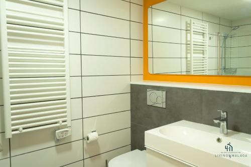 ein weißes Badezimmer mit Waschbecken und Spiegel in der Unterkunft Living4Malaga Arenal Superior Beach in Málaga