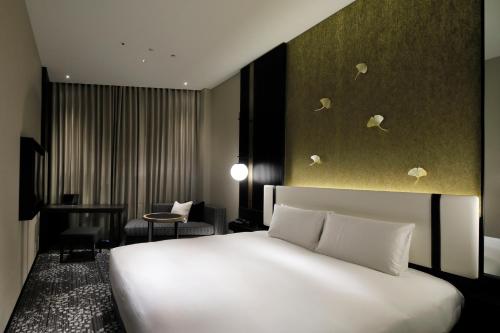 a bedroom with a large white bed in a room at KOKO HOTEL Premier Kumamoto in Kumamoto
