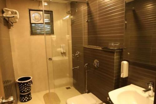 a bathroom with a shower and a toilet and a sink at Solitaire Resorts in Udaipur