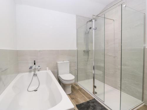 a bathroom with a tub and a toilet and a shower at The Cottage in Wimborne Minster