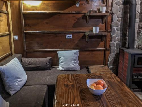 a living room with a couch and a bowl of fruit on a table at Tree House Gorski Lazi in Tršće