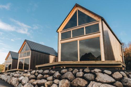a house with large windows on top of a pile of rocks at Skårungen - Hotel, Cabins and Camping in Kabelvåg