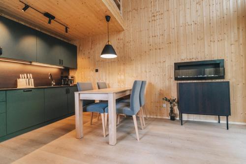 a kitchen with a wooden table and blue chairs at Skårungen - Hotel, Cabins and Camping in Kabelvåg