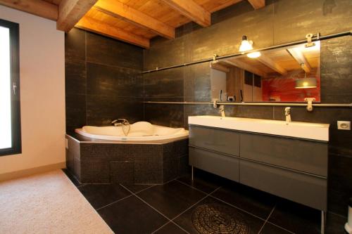 y baño con bañera, lavamanos y bañera. en Chalet Sno Lodge, en Les Deux Alpes