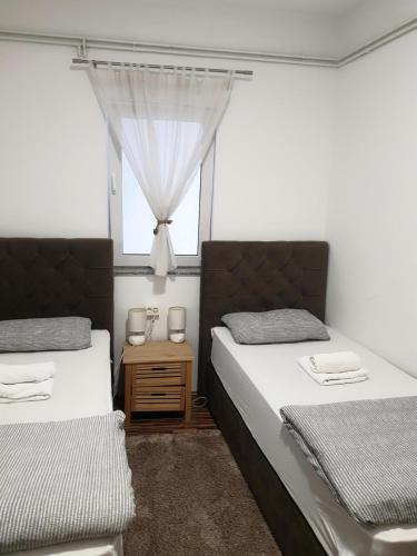 a bedroom with two beds and a window at Apartment Laura & Lucija in Osijek