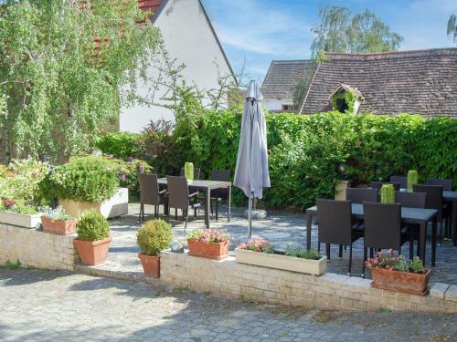 a patio with a table and an umbrella and plants at Holiday Home Hofgasse-2 by Interhome in Mörbisch am See