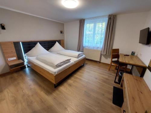 a bedroom with a bed and a desk and a table at Landgasthof Mörsbergei in Bubenreuth