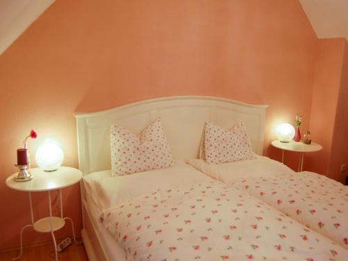 a bedroom with a white bed with pillows and two lamps at Apartment Hofgasse-1 by Interhome in Mörbisch am See