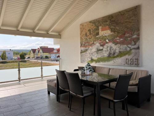 une salle à manger avec une table, des chaises et un tableau dans l'établissement Apartment Fuchs - DON161 by Interhome, à Donnerskirchen