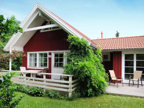 a red house with a porch and a patio at Chalet Friedrichsen I by Interhome in Langenhorn