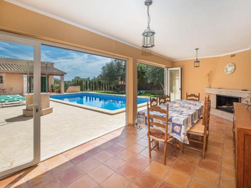una sala da pranzo con tavolo, camino e piscina di Holiday Home Peña Rubia by Interhome a Cala Murada