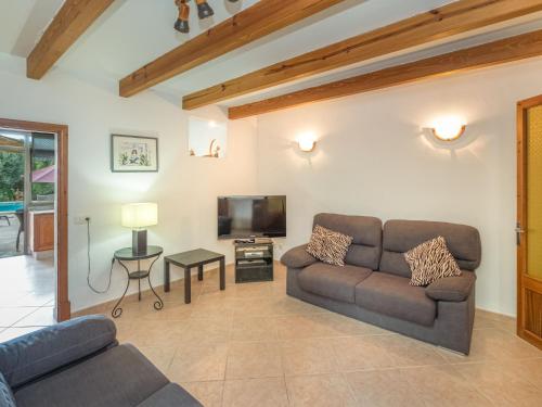 a living room with a couch and a tv at Holiday Home Sa Rossa - LOM227 by Interhome in Es Llombards