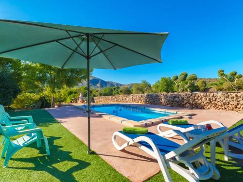 サン・リョレンツ・デス・カルダサルにあるHoliday Home Casa d'es Cardassar - LZO125 by Interhomeの芝生の椅子2脚とパラソル付きのプールがあります。