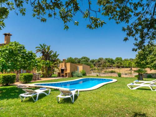 a yard with a swimming pool and lounge chairs at Holiday Home Es Coscolls - PIC300 by Interhome in Santa Margalida