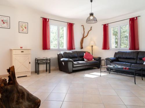 ロルグにあるHoliday Home La Renaudière - LOG165 by Interhomeのリビングルーム(革張りのソファ2台、赤いカーテン付)