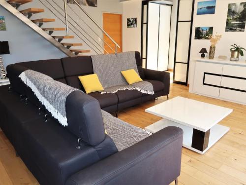 salon z czarną kanapą i białym stołem w obiekcie Holiday Home Ty Annik - TGC115 by Interhome w mieście Trégunc