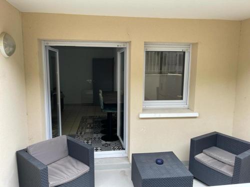 sala de estar con 2 sillas y ventana en Charmant T3: en plein coeur de Montargis, en Montargis