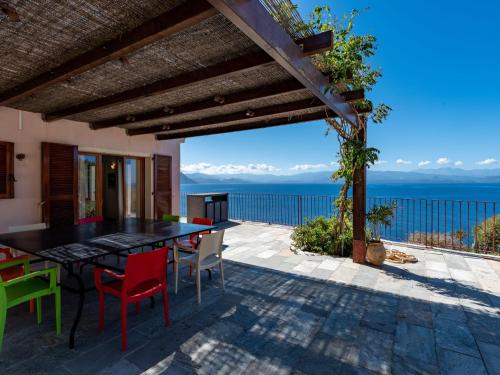 a patio with a table and chairs and the ocean at Holiday Home Maison Balbi by Interhome in Canari