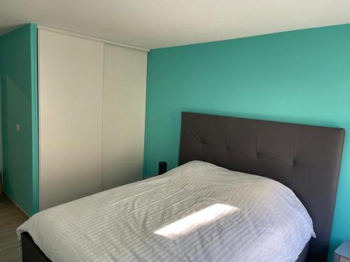 una camera con un letto con una parete blu di Charmant T3: en plein coeur de Montargis a Montargis