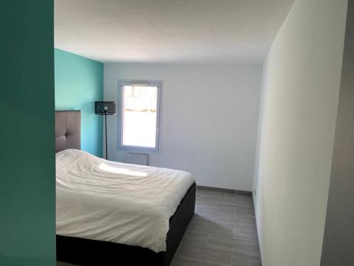 1 dormitorio con 1 cama en una habitación con ventana en Charmant T3: en plein coeur de Montargis, en Montargis