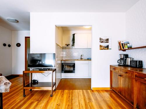 a kitchen with white cabinets and a wooden floor at Apartment Cisles by Interhome in Selva di Val Gardena